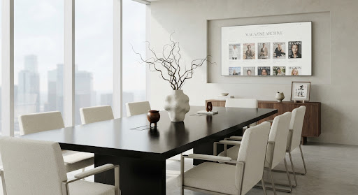 A minimalist, high-key photograph of a modern boardroom setting infused with subtle cultural artifacts. A sleek black oak table reflects soft, diffused daylight. In the center, a sculptural ceramic vase holds sparse, structural dry branches. The mood is authoritative yet serene, representing a new era of global executive leadership with a distinct aesthetic identity.